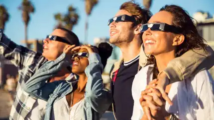 un grupo de amigos viendo al sol con lentes para eclipse solar